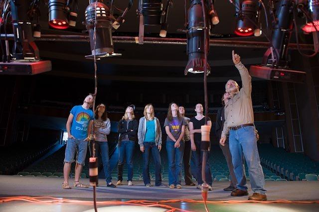 Larry Wheeler speaks to a group of students about the lighting in Van Ellis Theatre.